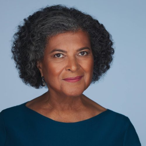 2022 june carol quigless10442 4×5 (1) A professional woman poses for the camera with a confident smile and radiant skin, thanks to a branding hair and makeup session with Whole Life Beauty.